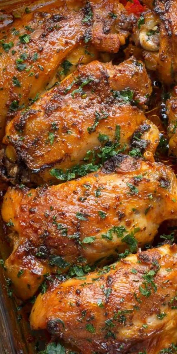 Delicious baked chicken thighs served on a plate with herbs and spices.