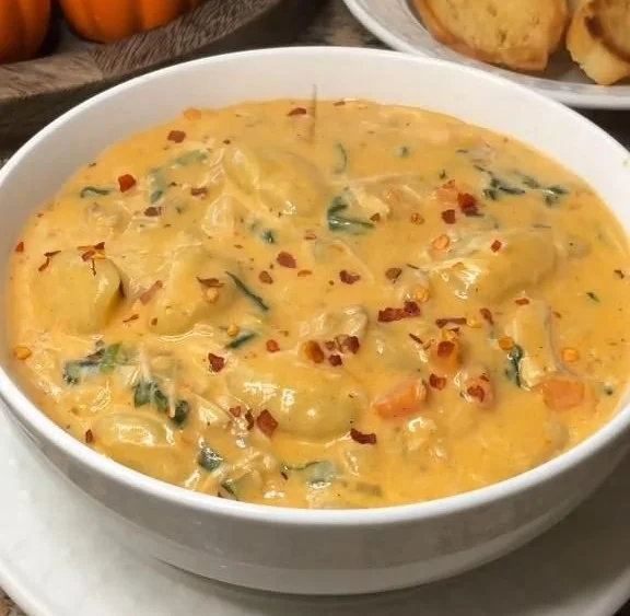 Bowl of Marry Me Chicken & Gnocchi Soup garnished with herbs and served warm