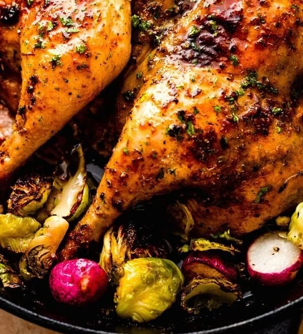 Oven roasted spatchcock chicken served on a platter with herbs and spices